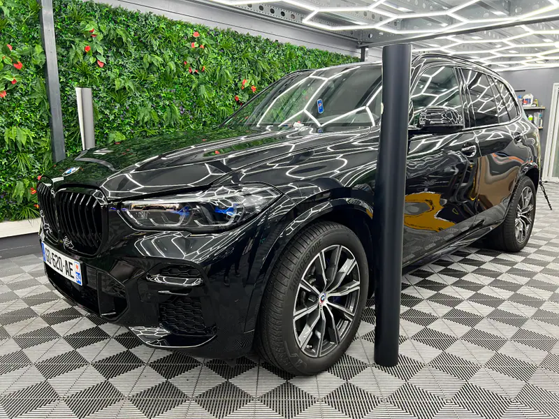 BMW X5 noir dans l’atelier MLK Auto à Villecresnes, pare-brise visible